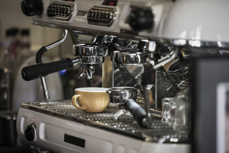 Coffee machine with coffee cup at cafe