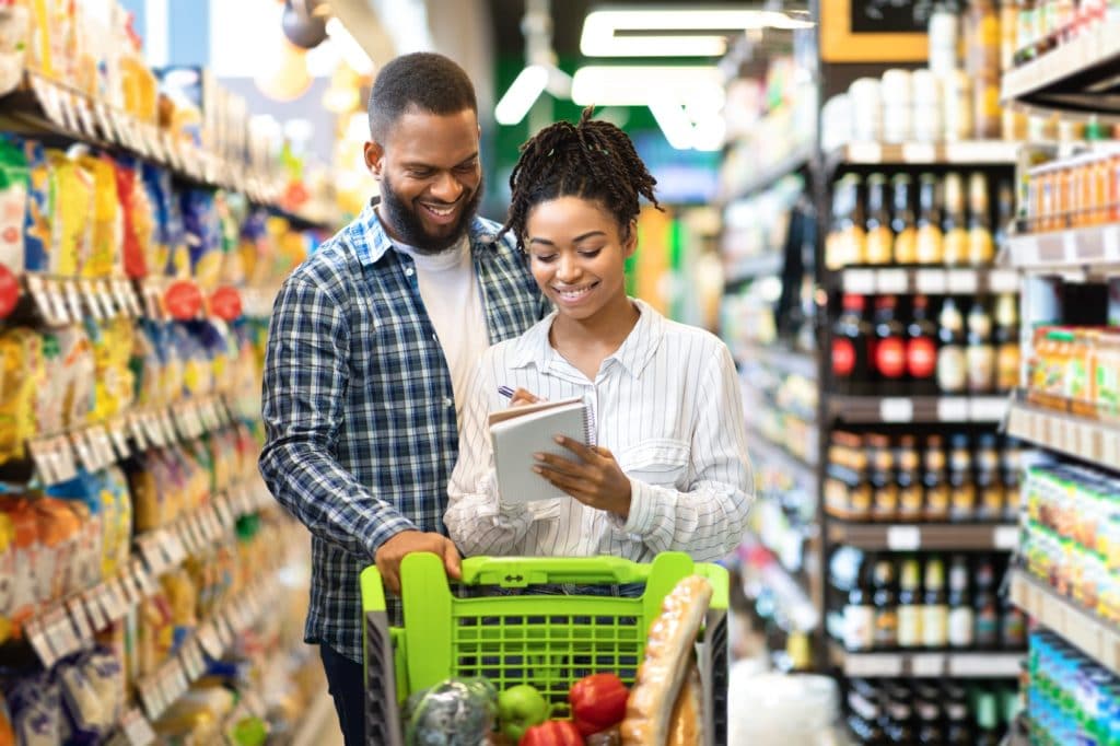 Happy Customers On Grocery Shopping, African Spouses Walking In Supermarket